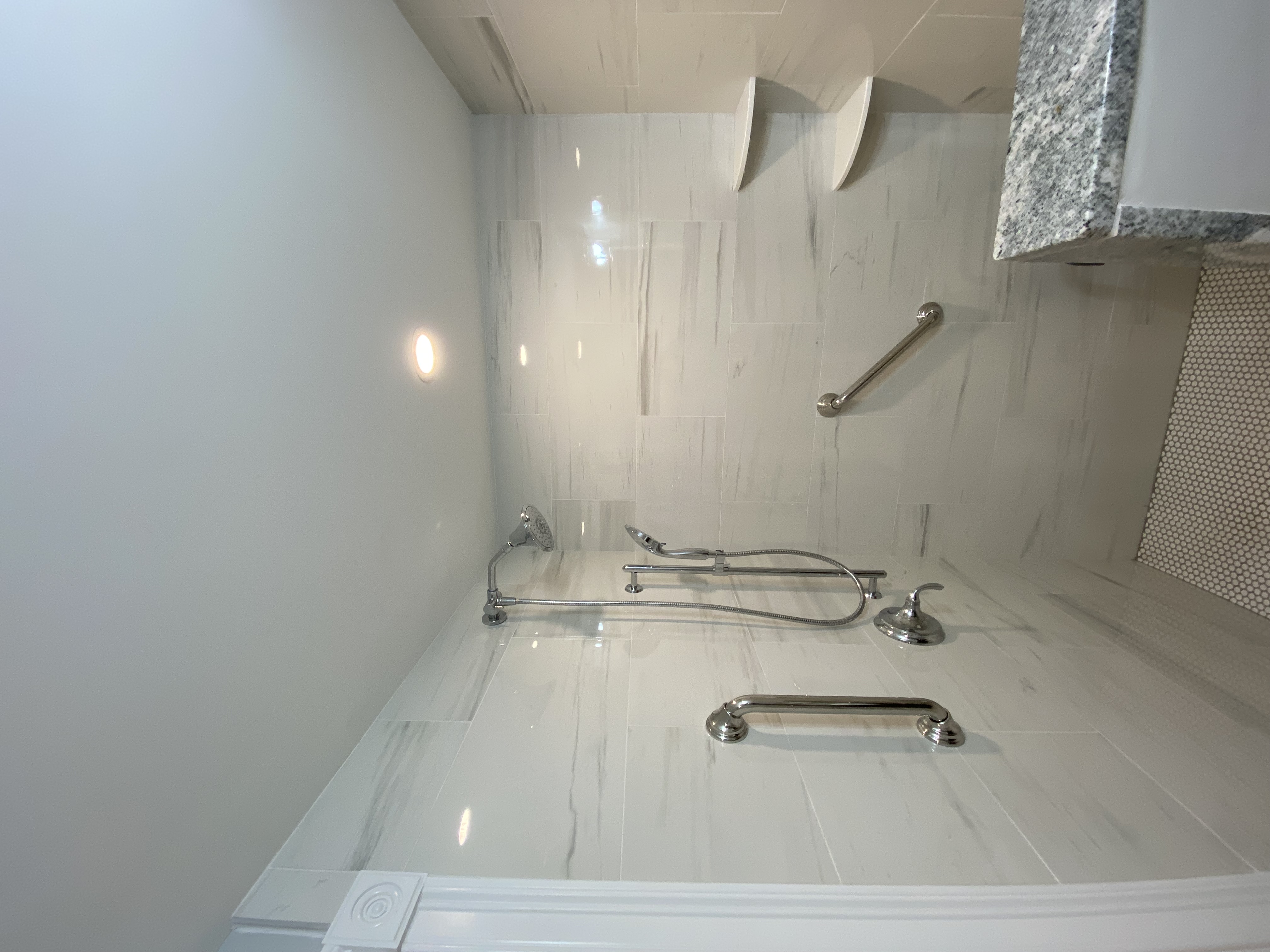Bathroom shower with marble tile and chrome fixtures